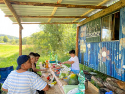 Kinder kochen Essen auf der Ferienfahrt, bereiten Salat zu
