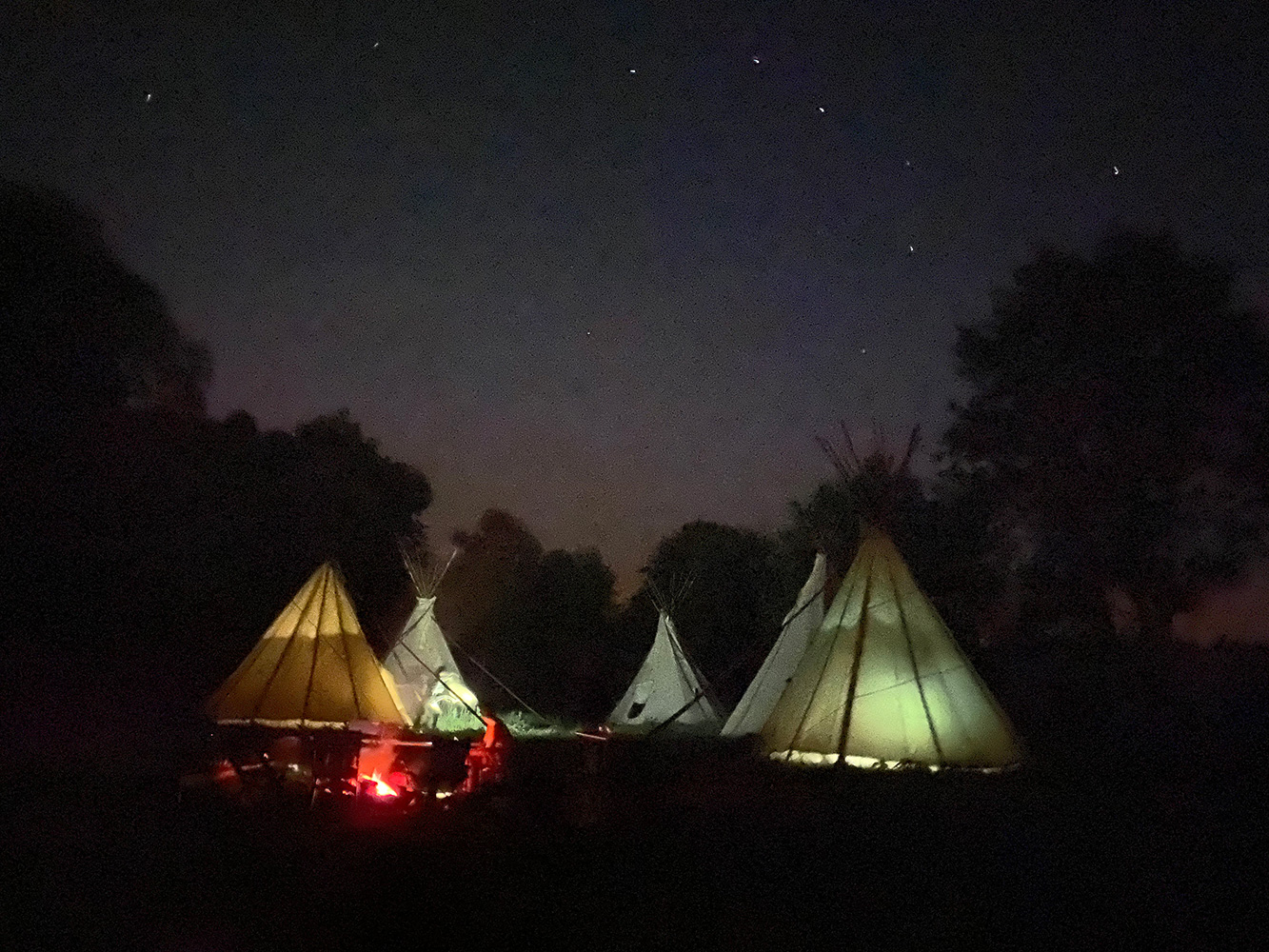 Tipi-Lager bei Nacht, Zelte bunt erleuchtet