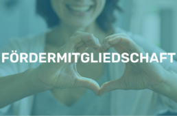 Frau mit lächeln im Gesicht zeigt mit ihren Händen ein Herz, blau eingefärbt mit der Aufschrift