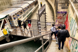 Jugendliche gehen Treppe runter zur Spree und betreten Sightseeing-Boot