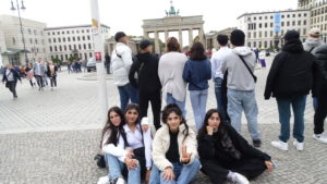 Jugendliche sitzen vorm Brandenburger Tor