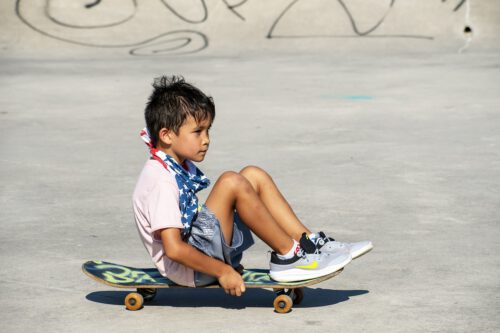 Junge sitzt auf Skateboard